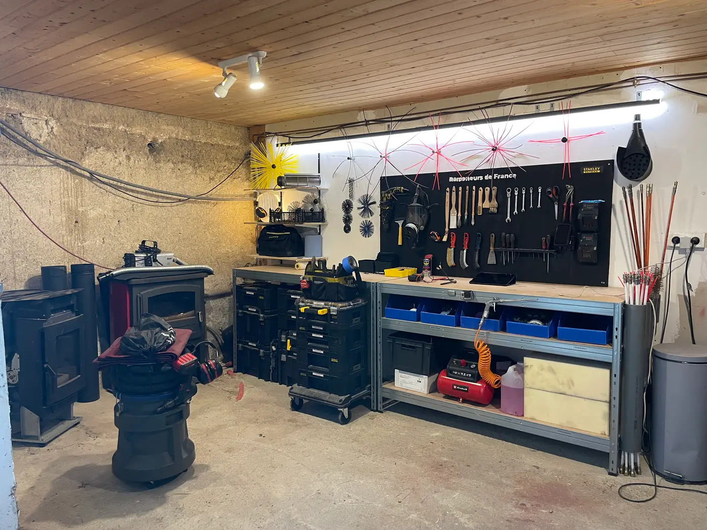 L'atelier équipé de Ramoneurs de France : cannes, hérissons et matériel de ramonage professionnel rangés
