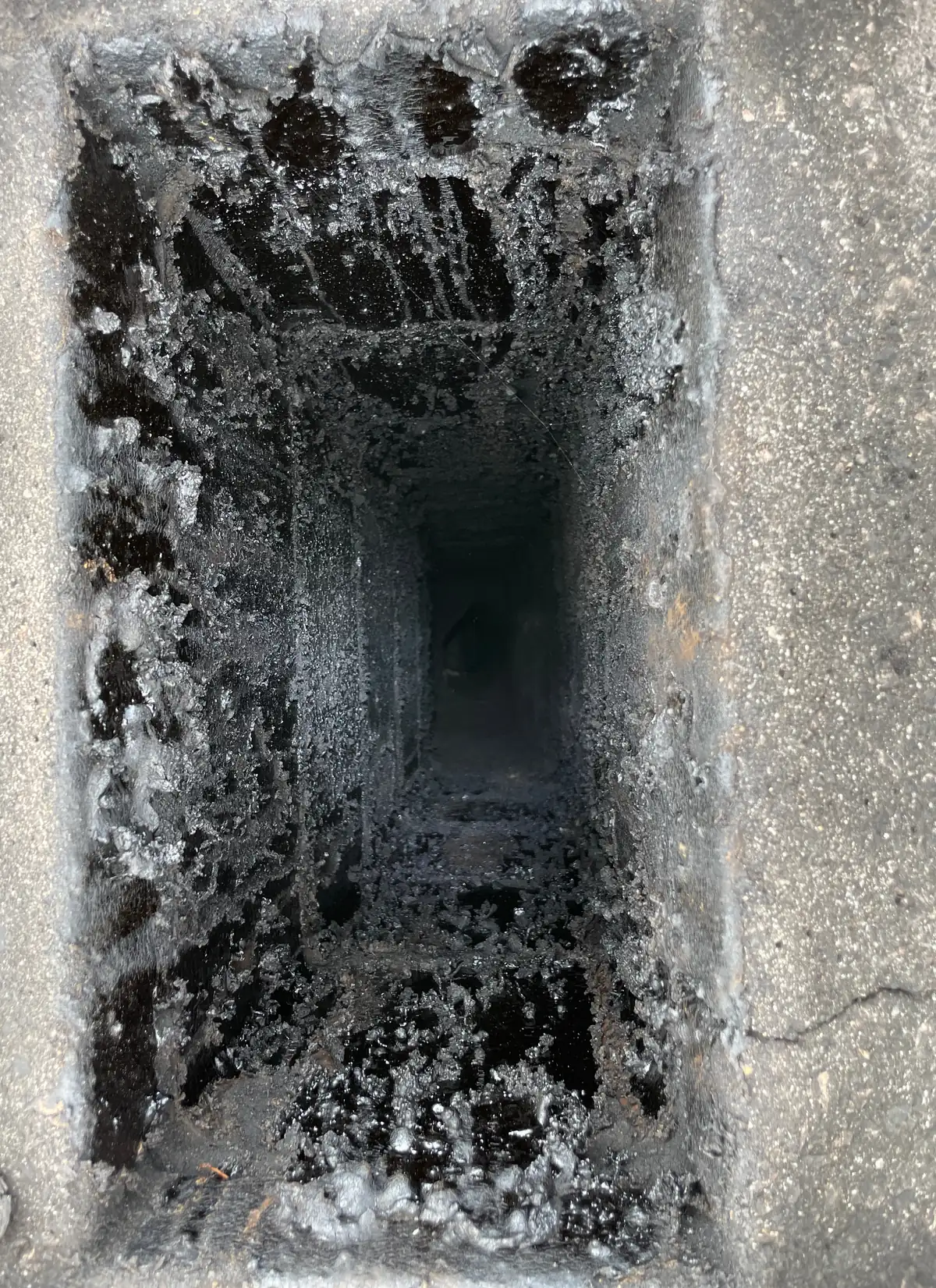 Boisseau de cheminée maçonné encrassé de goudron et de suie, avant ramonage