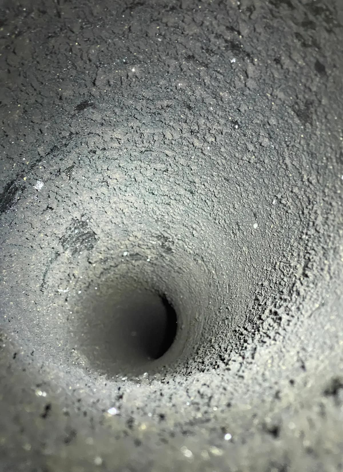 Intérieur d'un conduit de cheminée encrassé de suie, avant ramonage