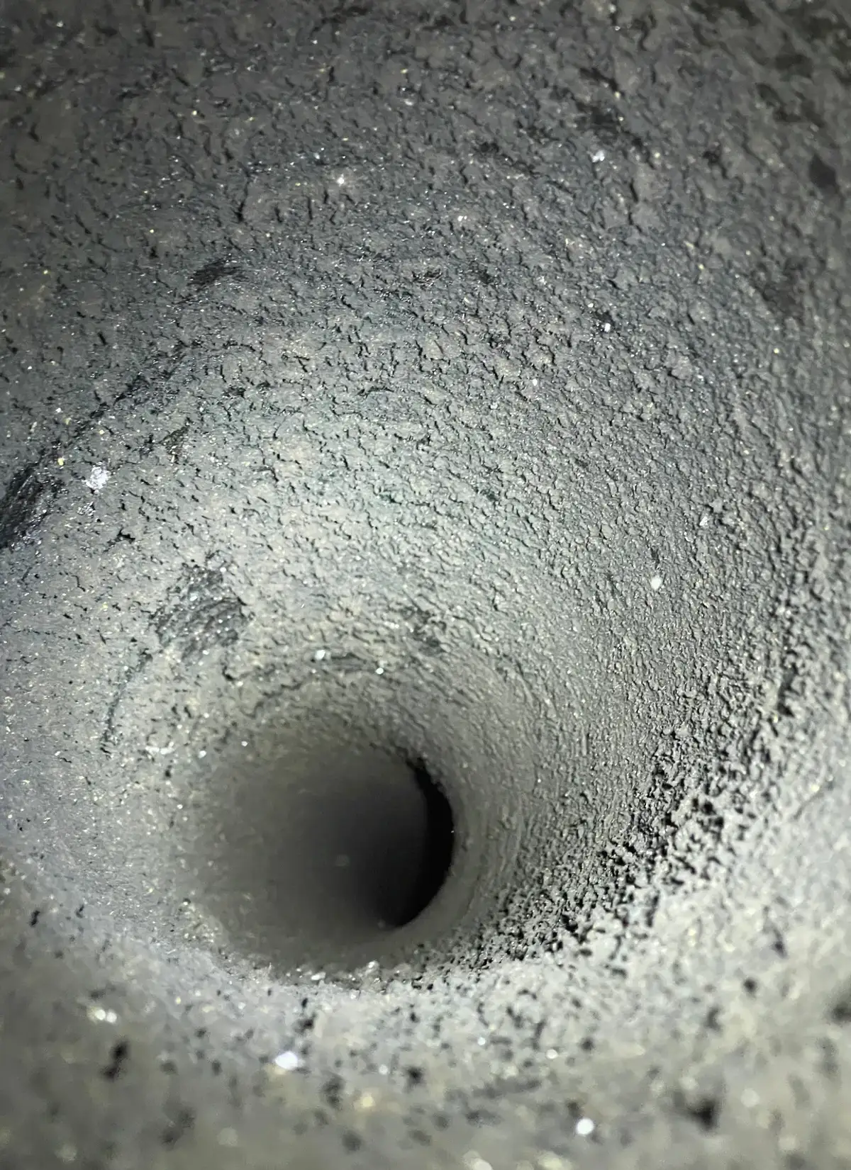 Intérieur d'un conduit de cheminée encrassé de suie, avant ramonage